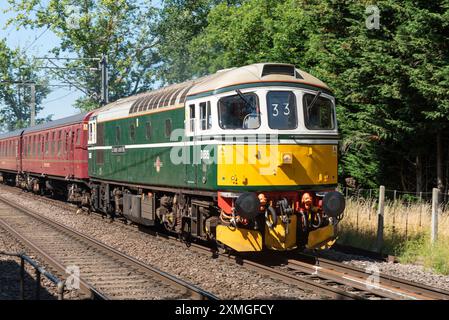 Ingatestone, Essex, Großbritannien. Juli 2024. Der Organisator UK Railtours betreibt einen klassischen dieselgeschleppten Personenzug vom Bahnhof London Fenchurch Street in die Küstenstadt Clacton-on-Sea in Essex, zunächst mit einer Lokomotive der British Rail Class 33 Nummer D6515 aus den 1960er Jahren bis nach Harwich. Eine Lokomotive der Baureihe 66 bringt den Zug nach Clacton und die Rückfahrt nach London. 98 dieselelektrische Lokomotiven der Baureihe 33 wurden zwischen 1960 und 1962 für die südliche Region der British Railways gebaut, die letzte wurde Mitte der 1990er Jahre ausgemustert Stockfoto