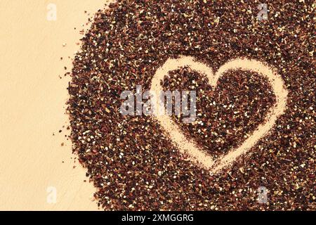 Herz auf verschüttetem Früchtetee gezeichnet, Textur. Blick von oben auf Tee aus Apfel, Zimt, Zitronenschale, Hibiskusblüten, Süßholzwurzel und Nelken. Tee gratis Stockfoto