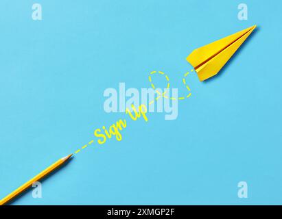 Konzepte für Anmeldung, Mitgliedschaft, Abonnement und Registrierung. Das Wort Registrieren mit gelbem Buntstift und einem Papierflugzeug auf blauem Hintergrund Stockfoto