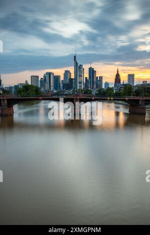 Blick Auf Frankfurt Bei Sonnenuntergang. Aufnahme mit Hintergrundbeleuchtung und Blick auf die Skyline. Wolkenkratzer Von Banken Und Versicherungsgesellschaften Im Finanzdistrikt Stockfoto