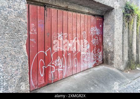 Salvador, Bahia, Brasilien - 27. Juli 2024: Graffiti an der hölzernen Garagentür eines alten Hauses in Pelourinho. Stadt Salvador, Bahia. Stockfoto