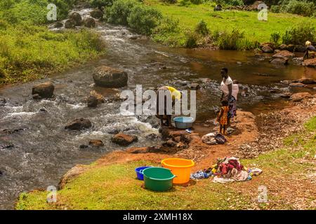 SIPI, UGANDA - 28. FEBRUAR 2020: Frauen aus der Region waschen im Fluss Sipi, Uganda Stockfoto
