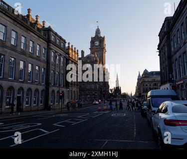 Balmoral Hotel Clock Tower mit Scott Monument hinter der Princes Street am späten Sommerabend in Edinburgh, schottischer Hauptstadt, 27. Juli 2024 Stockfoto