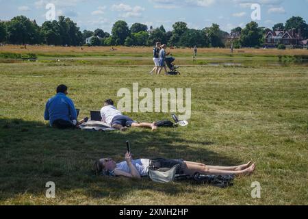 London, Großbritannien. 28. Juli 2024. Sonnensuchende, die sich in der warmen Sommersonne am Wimbledon Common im Südwesten Londons entspannen, da die Temperaturen in London und Südostengland in den nächsten Tagen voraussichtlich über 27celsius steigen werden. Credit: Amer Ghazzal/Alamy Live News Stockfoto