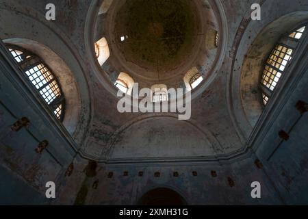 Innenansicht einer verlassenen Kirche mit einer großen Kuppel mit verfallenen Wänden und kaputten Fenstern. Das Bild zeigt das Archit der historischen Struktur Stockfoto