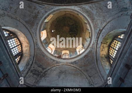 Das Innere einer verlassenen Kirche mit verfallenen Mauern, kaputten Fenstern und Schutt auf dem Boden. Die Bögen und gewölbten Decken geben einen Sinn Stockfoto