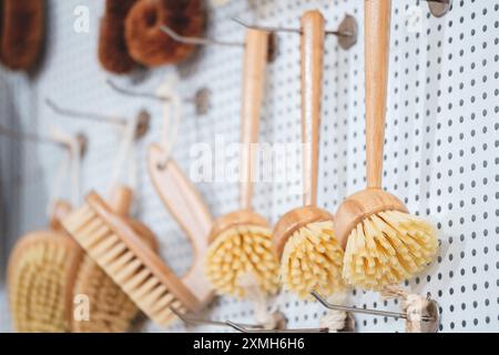 Eine Reihe von Holzbürsten hängt an einer Wand. Die Pinsel haben verschiedene Größen und Farben. Die Szene ist die von Organisation und Sauberkeit Stockfoto