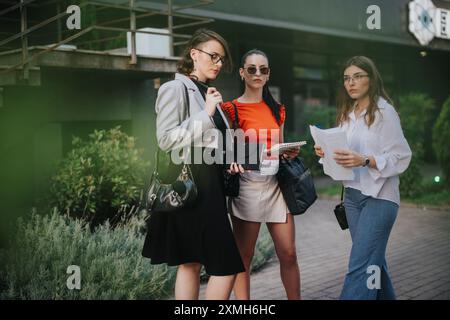 Gruppe von Geschäftsfrauen, die sich im Freien mit Dokumenten und Notizbüchern unterhalten Stockfoto