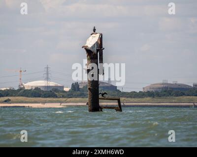 Sheerness, Kent, Großbritannien. Juli 2024. Nahaufnahmen des Schiffswracks der SS Richard Montgomery 1,5 Meilen nördlich von Sheerness, Kent (von einem Segelboot aufgenommen), von dem Experten glauben, dass es sich schneller verschlechtern könnte als erwartet, basierend auf dem neuesten veröffentlichten Bericht der Agentur Maritime and Coastguard. Das Schiff sank 1944 mit 1400 Tonnen Sprengstoff an Bord. Bild: Riesige LNG-Gastanks auf der Isle of Grain im Hintergrund. Quelle: James Bell/Alamy Live News Stockfoto