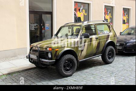Lada Niva Bronto Geländewagen, gemalt in Tarnfarben, parkt an einem Bürgersteig auf einer Kopfsteinpflasterstraße, Bautzen, Deutschland Stockfoto