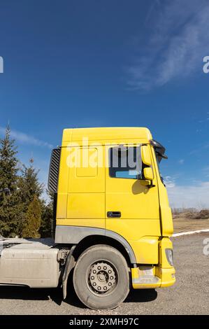Gelbes Fahrerhaus eines Lkws ohne Anhänger am blauen Himmel an einem sonnigen Tag. Nutzfahrzeuge, Fahrzeuge für den geschäftlichen Transport Stockfoto