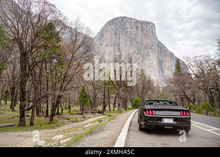 El Capitan Road durch den Yosemite National Park USA. Cabriolet während der Fahrt. Rückansicht eines Autos mit El Capitan im Hintergrund, berühmter Berg im Yosemite-Nationalpark, Roadtrip-Konzept Stockfoto