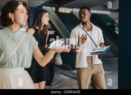 Multikulturelle Gruppe von Geschäftspartnern, die Finanzstatistiken und Wachstumsstrategien in einem modernen Arbeitsbereich diskutieren. Stockfoto