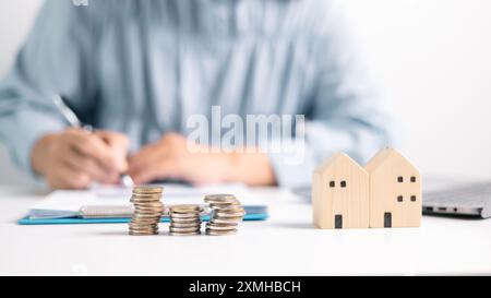 Investitionen in ein Haus beinhalten oft die Sicherung eines Hypothekarkredits, wobei ein Finanzagent bei der Verwaltung von Geschäfts- und Immobilienaspekten des Hauses hilft Stockfoto