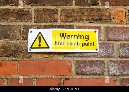 Warnung Anti-Climb-Lackschild an der Ziegelwand am Bahnhof, Melton, Suffolk, England, Großbritannien Stockfoto