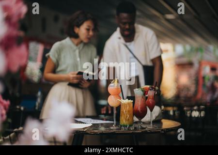 Multikulturelle Geschäftsleute genießen Drinks und jubeln den Erfolg in einer entspannten Umgebung im Freien an Stockfoto