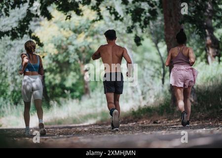 Freunde, die gemeinsam auf einem malerischen Pfad im Wald joggen Stockfoto