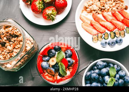 Dessert aus Erdbeeren und Heidelbeeren, Müsli und Joghurt, Hüttenkäse und Sahne. Ein zartes Parfait für ein gesundes Frühstück in einer weißen Schüssel und Stockfoto