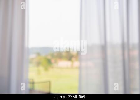 Fenstervorhang mit grünem Garten abstrakter Unschärfe Hintergrund Stockfoto