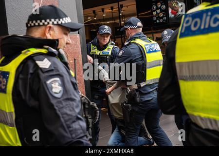 Eine Demonstrantin wird weggeschleppt, als sie verhaftet wird, nachdem sie sich weigerte, während der Demonstration auf Polizeibefehle zu hören. Das feuchte Wetter in Melbourne konnte die 42. Woche der wöchentlichen kostenlosen Palästinafahrtskundgebungen in Melbourne nicht stoppen. Diese Woche war die Polizei höher, sogar mit einem Passanten, der nun wöchentlich Mitglied des Protestes geworden ist. Sie wird verhaftet, nachdem sie sich weigerte, Polizeibefehle anzuhören. Stockfoto