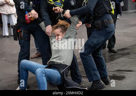 Eine Demonstrantin wird weggeschleppt, als sie verhaftet wird, nachdem sie sich weigerte, während der Demonstration auf Polizeibefehle zu hören. Das feuchte Wetter in Melbourne konnte die 42. Woche der wöchentlichen kostenlosen Palästinafahrtskundgebungen in Melbourne nicht stoppen. Diese Woche war die Polizei höher, sogar mit einem Passanten, der nun wöchentlich Mitglied des Protestes geworden ist. Sie wird verhaftet, nachdem sie sich weigerte, Polizeibefehle anzuhören. Stockfoto