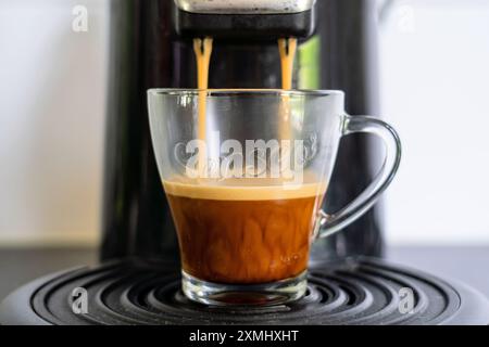 SENSEO Glasbecher mit frisch gebrühtem Kaffee aus der Kaffeepadmaschine Stockfoto