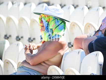 Hove UK 28. Juli 2024 - Fans genießen die heiße Sonne und bleiben vor den Strahlen geschützt, während sie das Cricket-Spiel zwischen Sussex Sharks und Warwickshire auf dem 1st Central County Ground in Hove sehen: Credit Simon Dack /TPI/ Alamy Live News Stockfoto