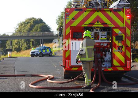 Die Polizei blockiert die Canal Road in Leeds, während die Feuerwehr ein brennendes Gebäude in Canal Mills in der Armley Gegend von Leeds, West Yorkshire, Großbritannien, betreut Stockfoto