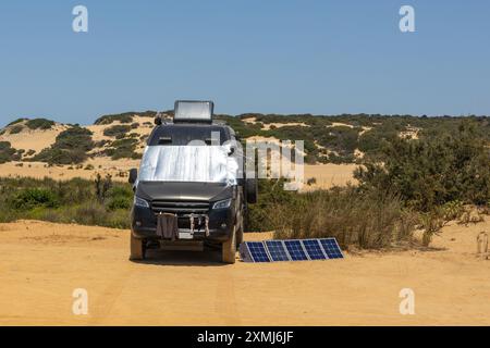 Schwarzer Wohnwagen mit Solarpaneelen in Wüstenlandschaft Stockfoto