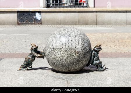 "Sisyphus" - zwei Zwergfiguren, die eine Steinkugel am Marktplatz, Altstadt, Breslau, Schlesien, Polen schieben Stockfoto