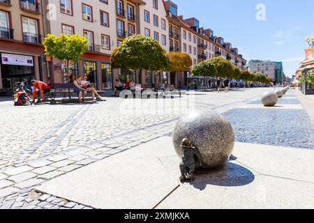 GNOME-Figur schiebt eine Steinkugel am Marktplatz, Altstadt, Breslau, Schlesien, Polen Stockfoto