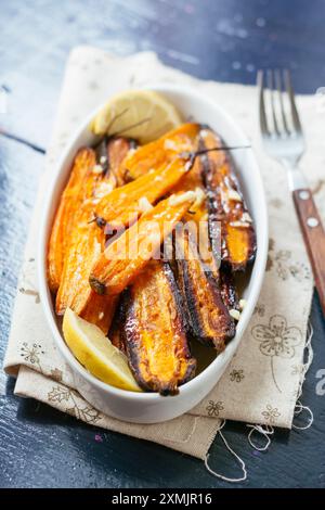 Hausgemachte Beilage mit gebackenem lila und normalen Karotten mit Knoblauch und Limette. Stockfoto