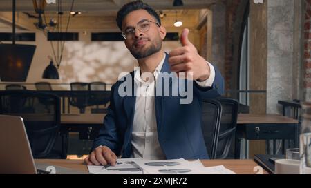 Arabian Indian Guy man ethnischer männlicher lächelnder Geschäftsmann, der Laptop am Arbeitsplatz arbeitet glücklich zeigt Daumen nach oben Geste angehobener Finger Stockfoto