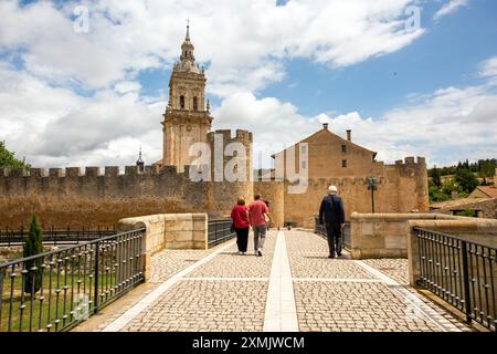 Menschen laufen in Richtung der mittelalterlichen spanischen Stadtmauer El Burgo de Osma und ihrer Kathedrale in der Provinz Soria Castile und Leon Spanien Stockfoto