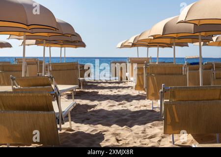 Leerer Strand mit Sonnenschirmen und Liegestühlen Stockfoto