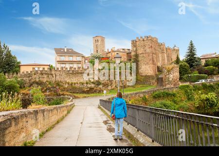 Frau, die in Richtung der spanischen mittelalterlichen Stadt El Burgo de Osma und ihrer Kathedrale in der Provinz Soria Castile und Leon Spanien geht Stockfoto