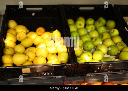 Zitronen und Äpfel in Kisten auf dem Markt Stockfoto