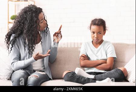 Wütend schwarz Mama schimpfen Freche kleine Tochter zu Hause Stockfoto