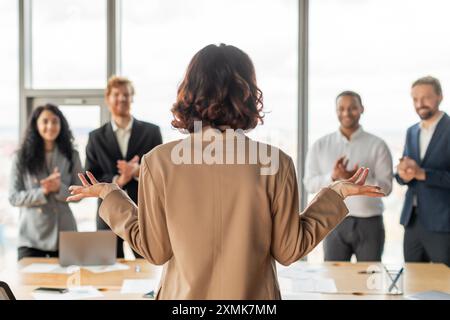 Geschäftsfrau spricht Kollegen während der Präsentation in Modern Office an Stockfoto