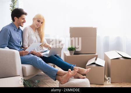 Ein Paar plant ein neues Zuhause, während er auf dem Sofa sitzt Stockfoto