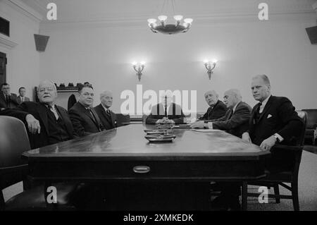 Mitglieder der Warren-Kommission versammelten sich an einem Tisch, darunter (links-rechts) der ehemalige CIA-Direktor Allen W. Dulles, der Abgeordnete Hale Boggs, der Senator John Sherman Cooper, der Vorsitzende des Chief Justice Earl Warren, der Senator Richard B. Russell, John J. McCloy und der Abgeordnete Gerald R. Ford Stockfoto