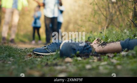 Das Suchtruppenteam findet unerkennbare barfuß tote Leiche im Wald, Retter rufen die Polizei, um den mysteriösen grausamen Mord zu erledigen. Hoffnungslose Leiche im Wald ermordet. Kamera A.. Stockfoto