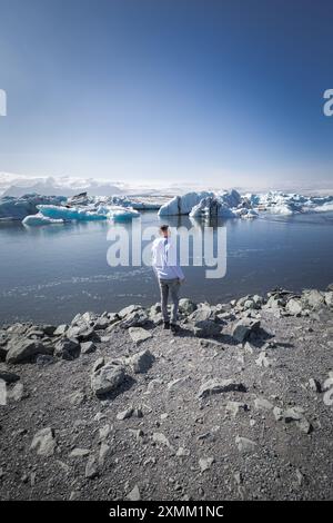 Person, die Eisberge in der Jokulsarlon Glacial Lagoon, Island, bestaunt Stockfoto