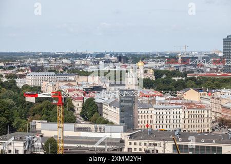 Dieses Bild bietet ein Luftpanorama des Stadtzentrums von Riga, Lettland, mit Schwerpunkt auf Kräne und Baustellen. Es veranschaulicht die fortwährende urbane Entwicklung Stockfoto