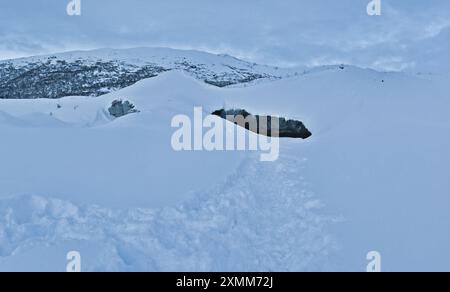 Pfad im tiefen Schnee führt zur Castner Cave, einer Eishöhle in Alaska. An einem Wintertag. Stockfoto