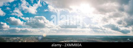 Eine atemberaubende Himmelslandschaft mit hellem Sonnenlicht und flauschigen Wolken, die eine fesselnde Aussicht schaffen Stockfoto