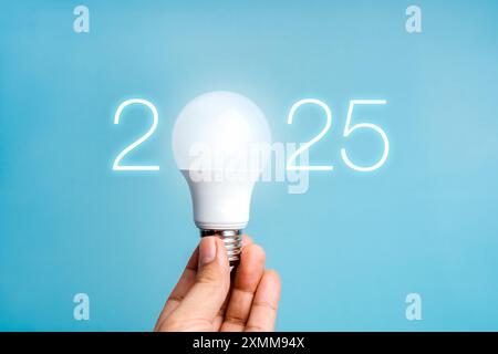 Frohes neues Jahr 2025 mit kreativer Idee, Geschäftsinnovation und Technologietrends. Leuchtende Zahlen für 2025 Kalenderjahre mit glühender Glühlampe Stockfoto