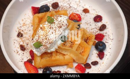 Köstliche hausgemachte Waffeln mit Schlagsahne, frischen Beeren, Stockfoto