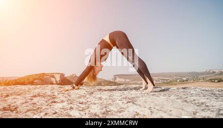 Frau, die Yoga auf dem Berggipfel praktiziert Stockfoto