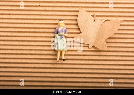 Frau Figur platziert neben einem Papier Schmetterling Form Stockfoto